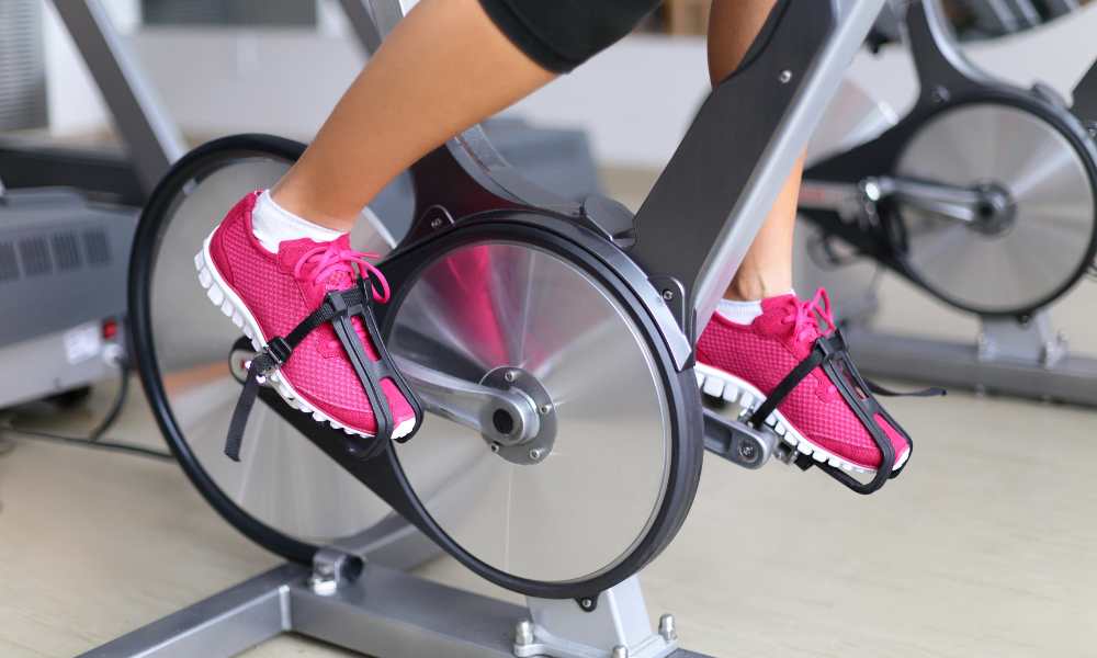 Healthy lifestyle concept, woman working out indoors, air bike vs spin bike
